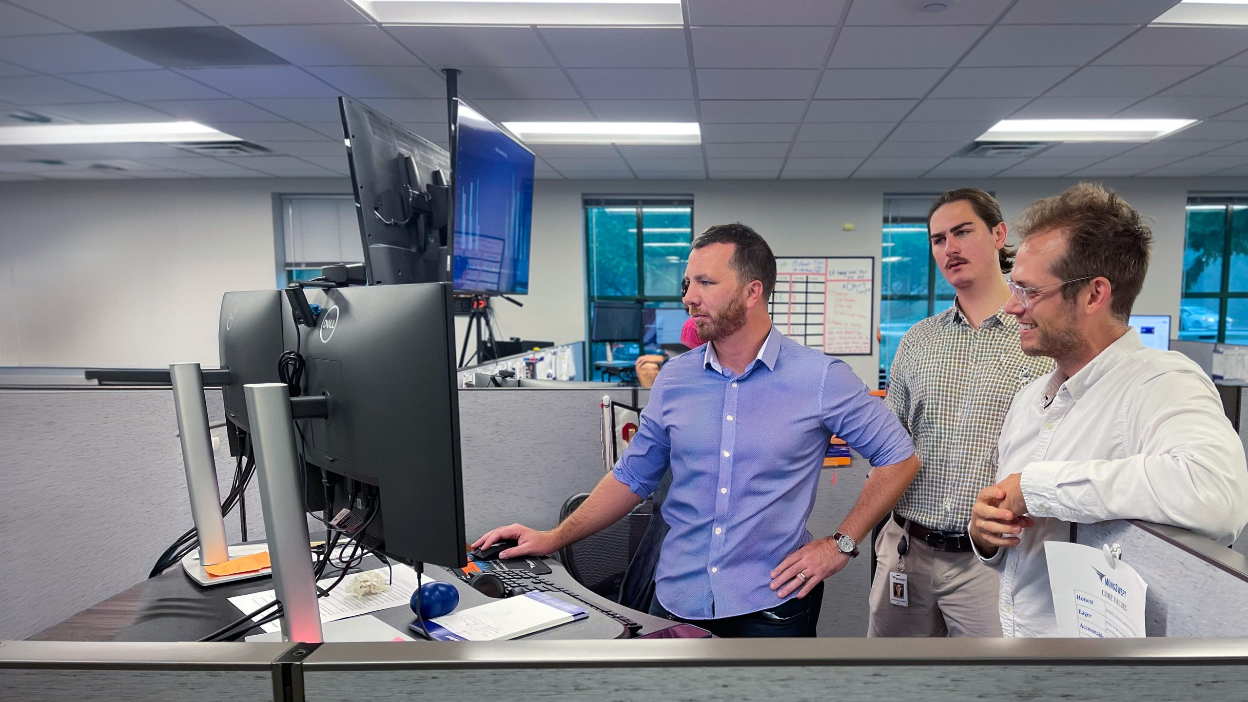 Three WingSwept Employees working on a computer in the office
